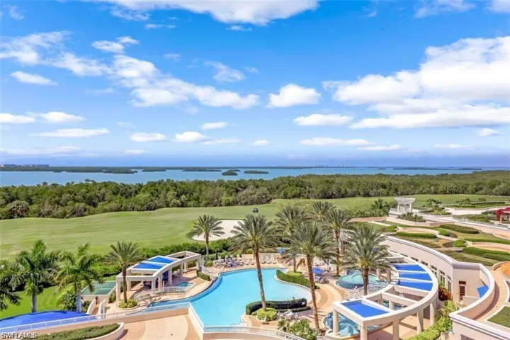 Community pool featuring a patio area and a water view