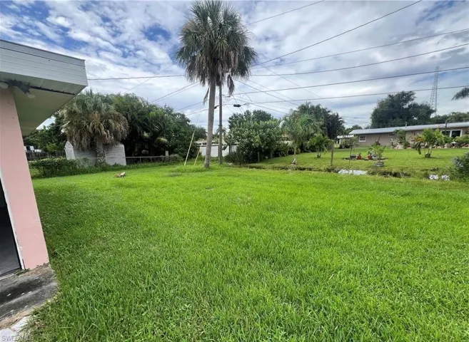 Expansive green lawn with mature palm trees and landscaping
