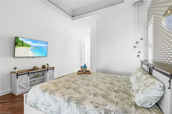 Primary Bedroom w/ pool view and flatscreen tv