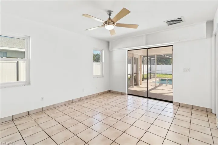 Primary bedroom with pool sliding glass door and ceiling fan