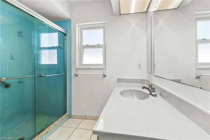 Shower with sliding glass door.