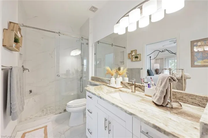 Bathroom with vanity, toilet, and a shower with shower door