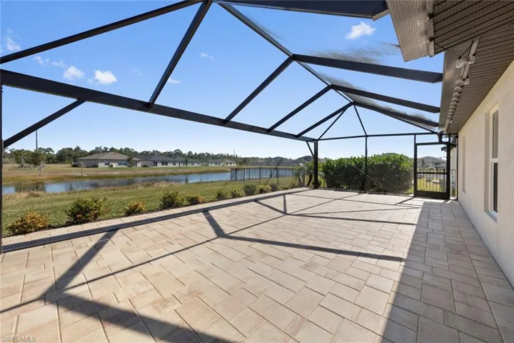 View of patio with a lanai and a water view