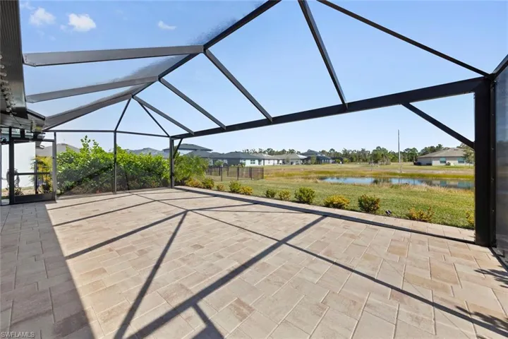 View of patio featuring a water view and glass enclosure