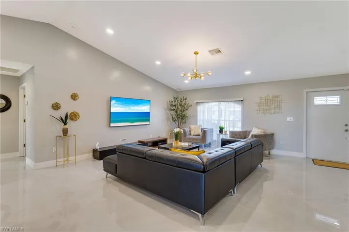 Living area with an inviting chandelier, baseboards, visible vents, and recessed lighting
