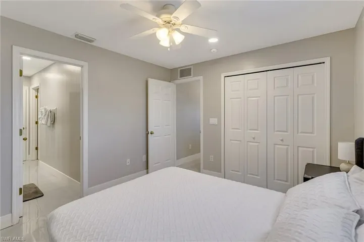 Bedroom with visible vents, baseboards, ceiling fan, and a closet