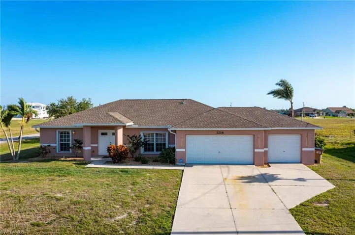Ranch-style house with concrete driveway, stucco siding, an attached garage, and a front lawn
