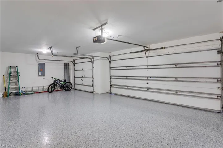 Garage featuring a garage door opener and electric panel