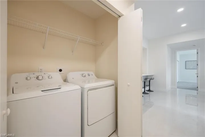 Clothes washing area featuring independent washer and dryer, light tile patterned floors, baseboards, laundry area, and recessed lighting
