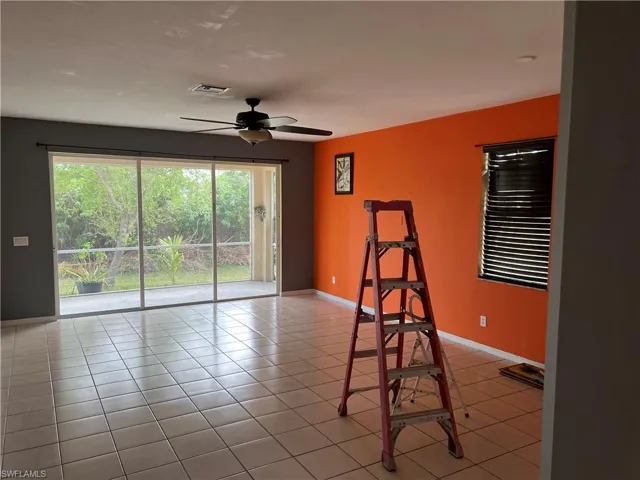 Tiled empty room featuring visible vents, baseboards, and ceiling fan
