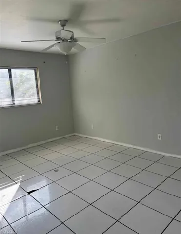 Empty room featuring ceiling fan and light tile patterned flooring
