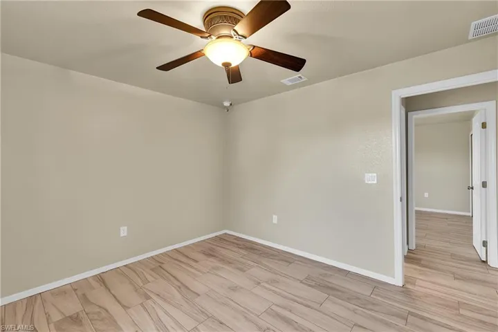 Unfurnished room with light wood-style flooring and a ceiling fan