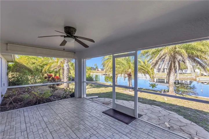Unfurnished sunroom featuring ceiling fan, a water view, and healthy amount of natural light