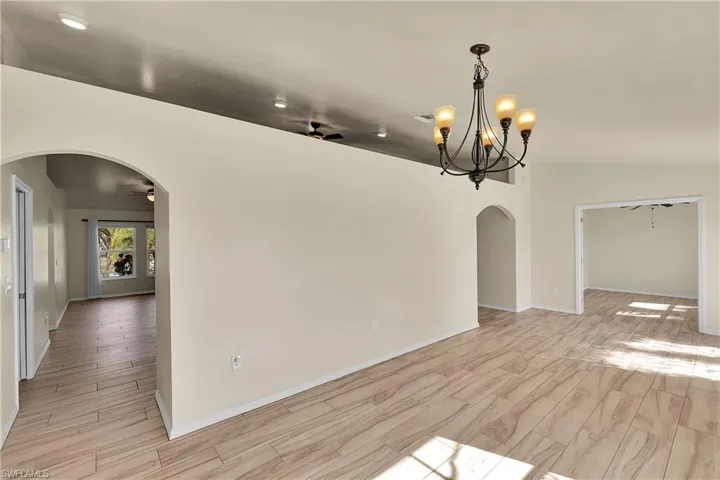 Unfurnished dining area featuring ceiling fan, arched walkways, and wood tiled floors