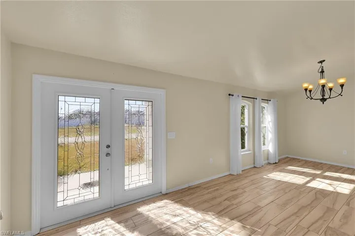 Doorway featuring a chandelier, french doors, and wood finish floors