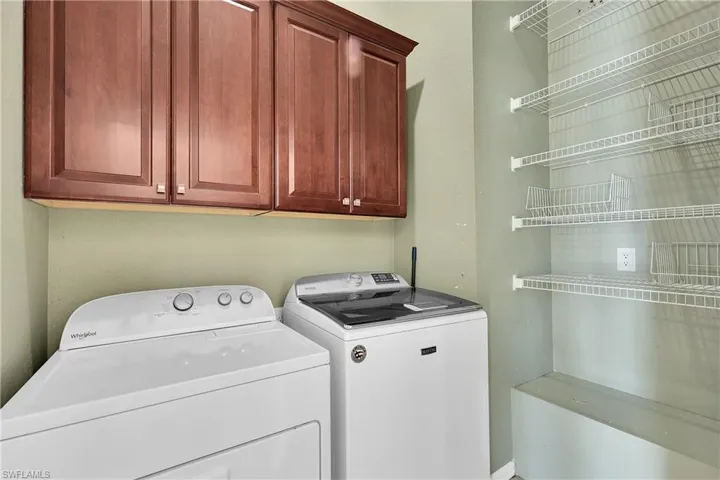Laundry area featuring independent washer and dryer and cabinet space