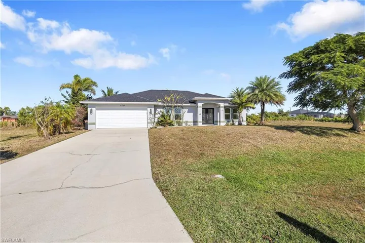 Ranch-style house with a front lawn, driveway, and an attached garage
