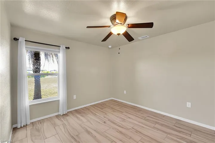 Spare room featuring a water view and a ceiling fan