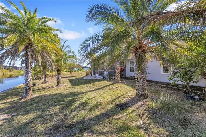 View of grassy yard with a water view and a patio area