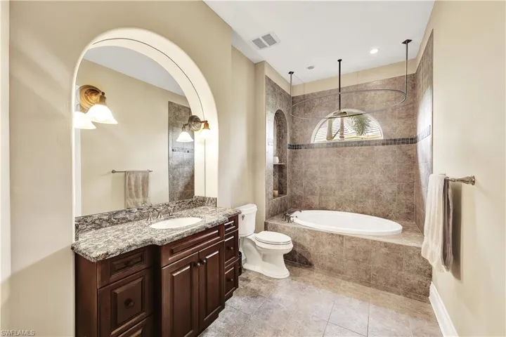 Full bathroom with vanity, toilet, plus walk in shower, and tile patterned floors