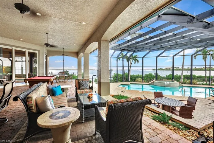 Outdoor Lanai lounge area with pool table, firepit, 2 dining areas, endless water views