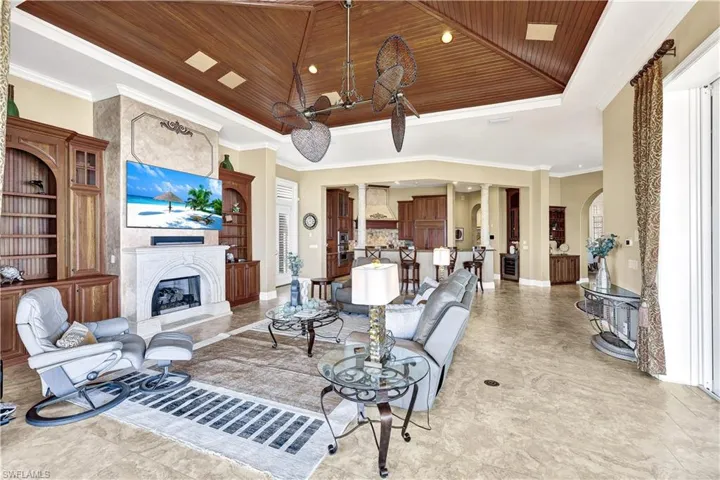 expansive family room with custom carved coquina fireplace, custom plantation shutters