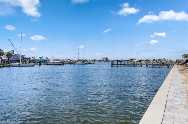 Waterfront property with a concrete seawall, paver-lined embankment, and direct water access