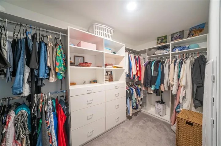This walk-in closet features extensive built-in shelving, drawers, and hanging rods, providing ample storage solutions
