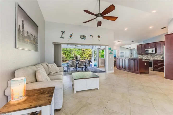 Living room with a sunroom, ceiling fan, and recessed lighting