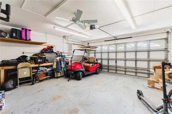 Garage featuring ceiling fan and a garage door opener