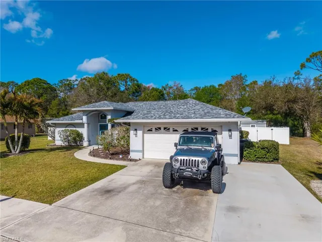 Ranch-style home with a front lawn, stucco siding, driveway, roof with shingles, and an attached garage