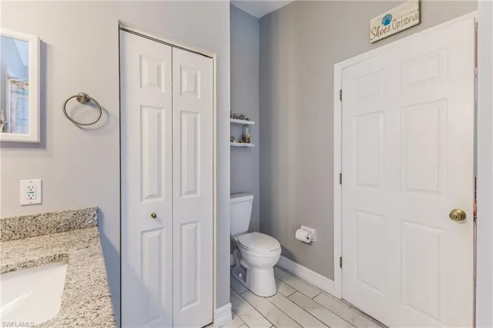 Half bathroom with vanity and a closet