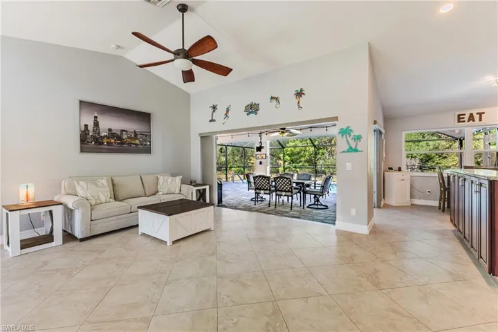 Living area featuring a sunroom, a ceiling fan, plenty of natural light, and a high ceiling