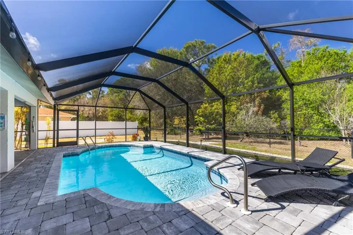 View of pool featuring a sunroom, a lanai, and patio surround