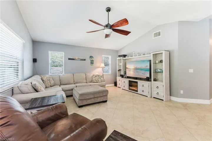 Living room with lofted ceiling and a ceiling fan