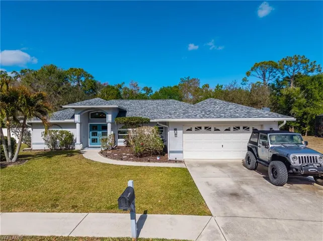 Ranch-style home with a front lawn, concrete driveway, a garage, and stucco siding