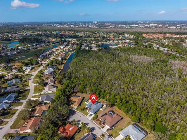 Aerial perspective of suburban area featuring a nearby body of water