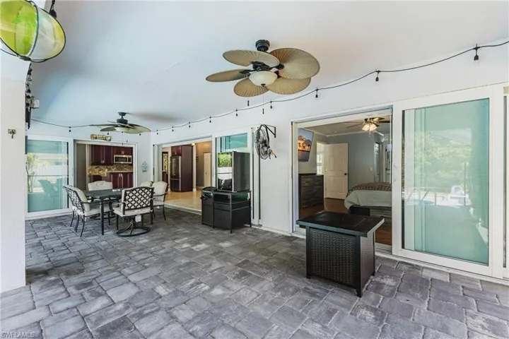 View of patio with outdoor dining area and ceiling fan