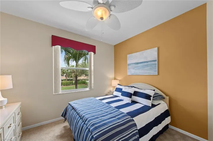 Bedroom with light colored carpet and ceiling fan