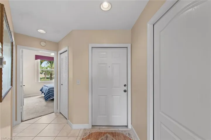 Entryway featuring recessed lighting, light tile patterned floors, and light carpet