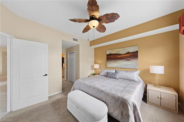 Bedroom featuring a closet, ceiling fan, and light colored carpet