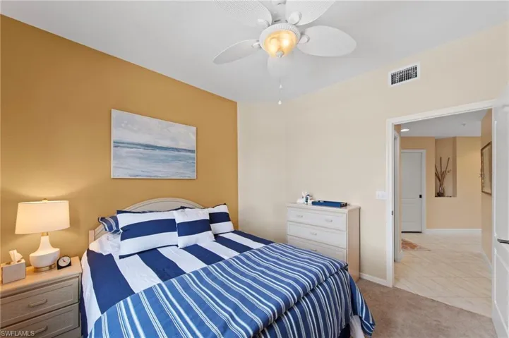 Bedroom featuring ceiling fan, light colored carpet, and light tile patterned flooring