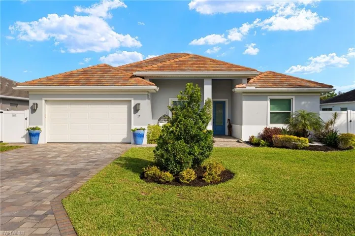 View of front of property with a gate, a tile roof, a garage, stucco siding, and driveway