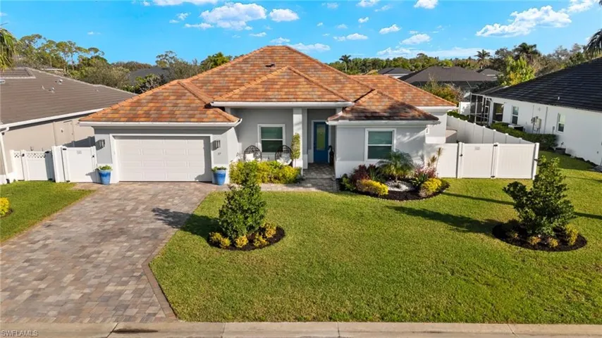 View of front of property featuring a gate, an attached garage, stucco siding, and driveway