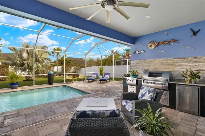 View of swimming pool with patio surround, a sunroom, a lanai, and a fenced backyard