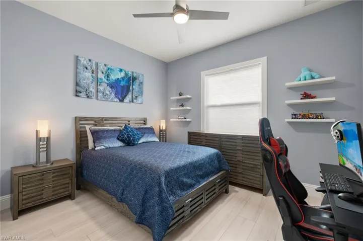 Bedroom featuring an office area, a ceiling fan, and light wood-type flooring