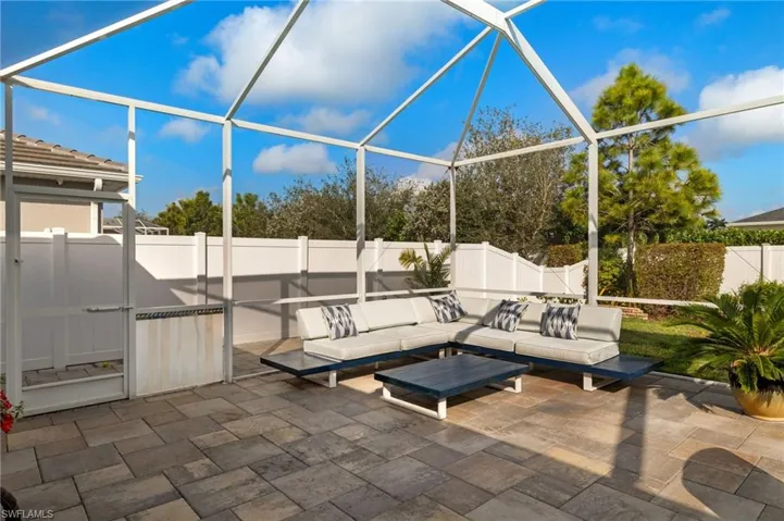 Fenced backyard featuring a lanai, a sunroom, and outdoor furniture