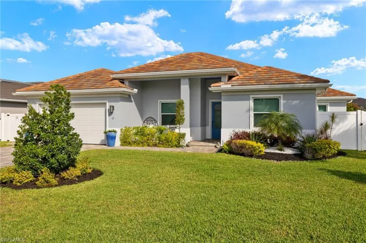 View of front of home with an attached garage, stucco siding, a tile roof, and driveway