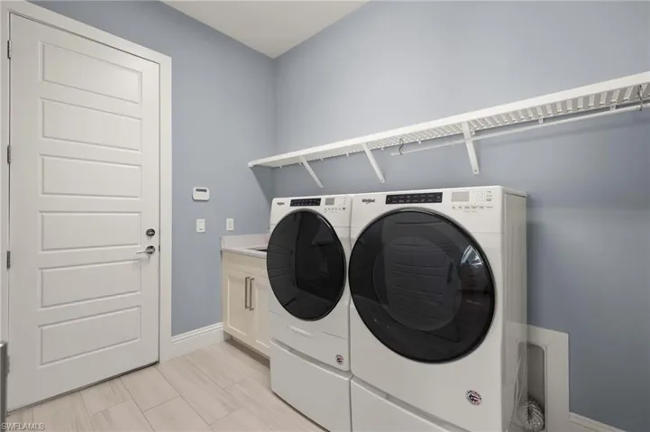 Laundry room featuring washer and clothes dryer and cabinet space