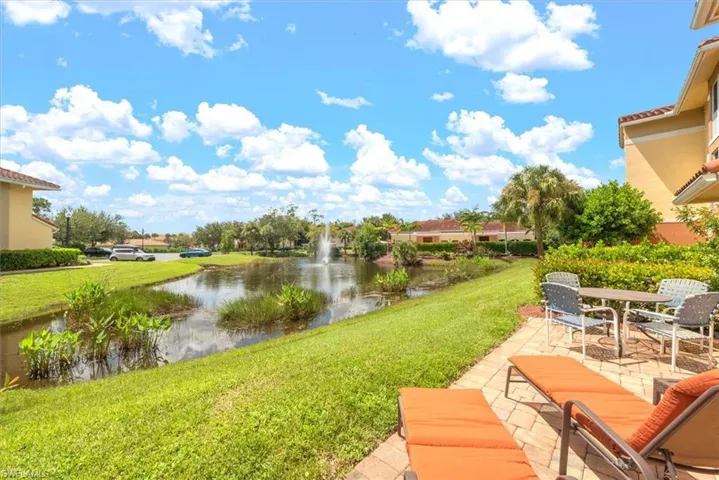 View of green lawn with a patio and a water view